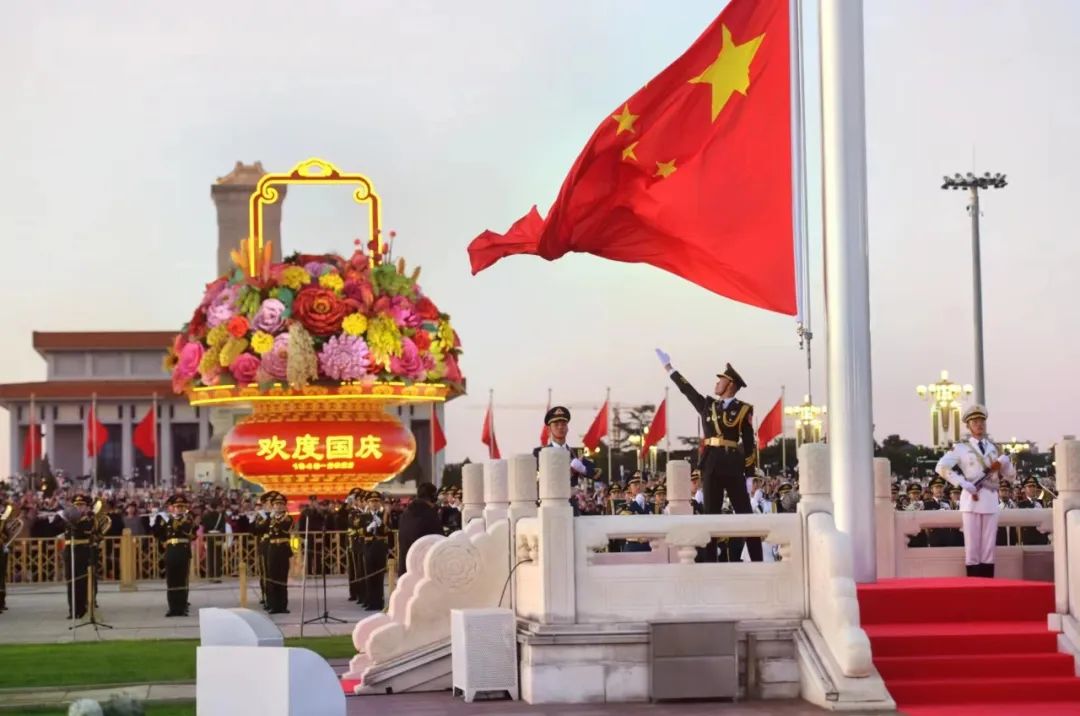 升旗手高高扬起国旗,鲜艳的五星红旗迎风招展 升旗手高高扬起国旗,鲜艳的五星红旗迎风招展