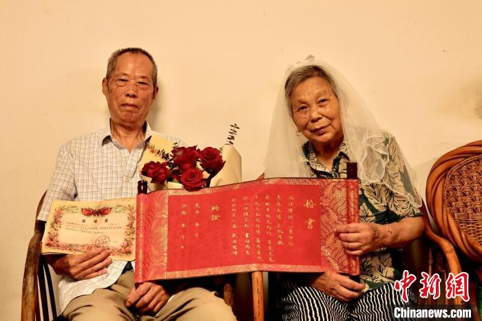 “钻石婚”夫妇拿着手写婚书 “钻石婚”夫妇拿着手写婚书